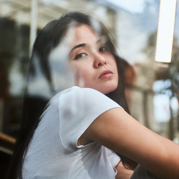 Person sitting in a calm, meditative pose with soft lighting.